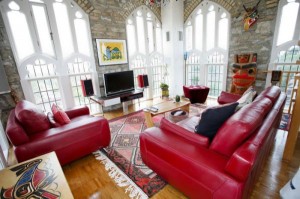 This church built in 1910 was converted into a modern penthouse home. The original arched windows and stone masonry were preserved while modern electronics, original art and red leather couches brighten up the space. 